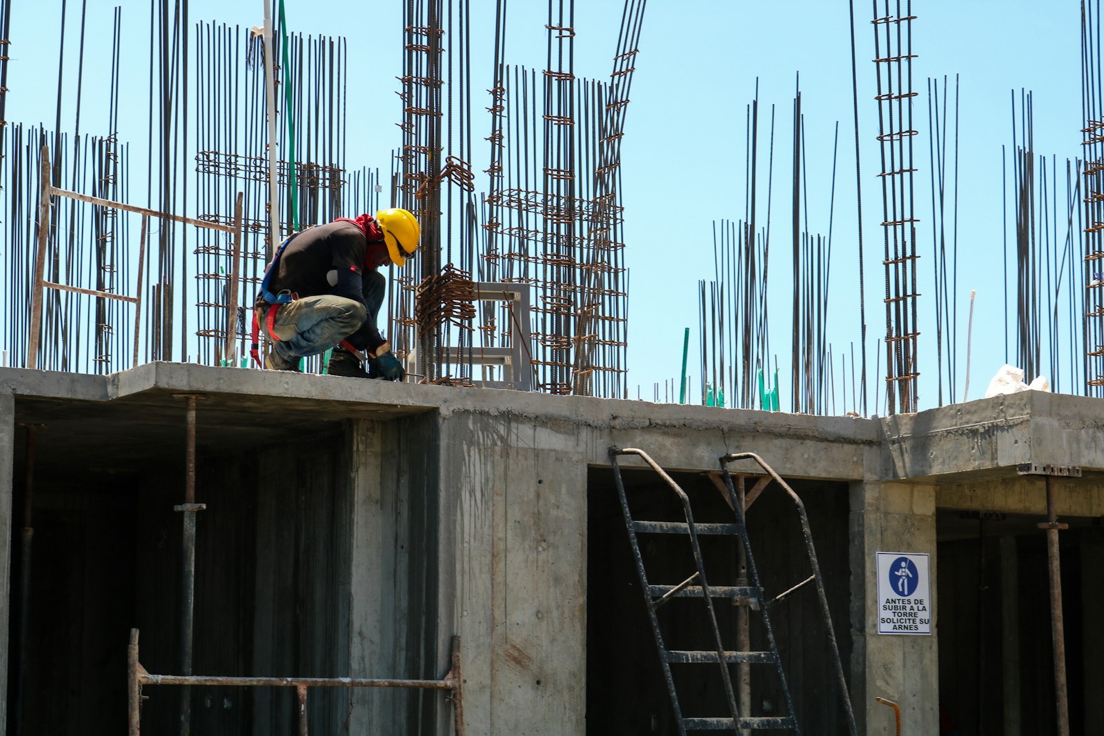 Sobre Construcciones Benavent man kneeling on unfinished building during daytime